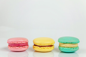 Sweet almond colorful pink, blue, yellow macaron or macaroon dessert cake isolated on white background. French sweet cookie. Minimal food bakery concept. Copy space