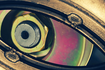 Unusual robotic eye in steampunk style in faded tones. Focused robot look. Golden background pattern close-up.