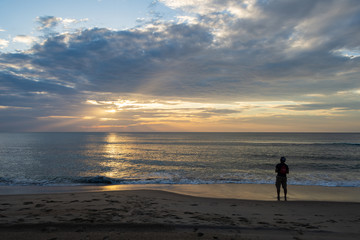silhouette of young man enjoying the sunrise on virginia beach