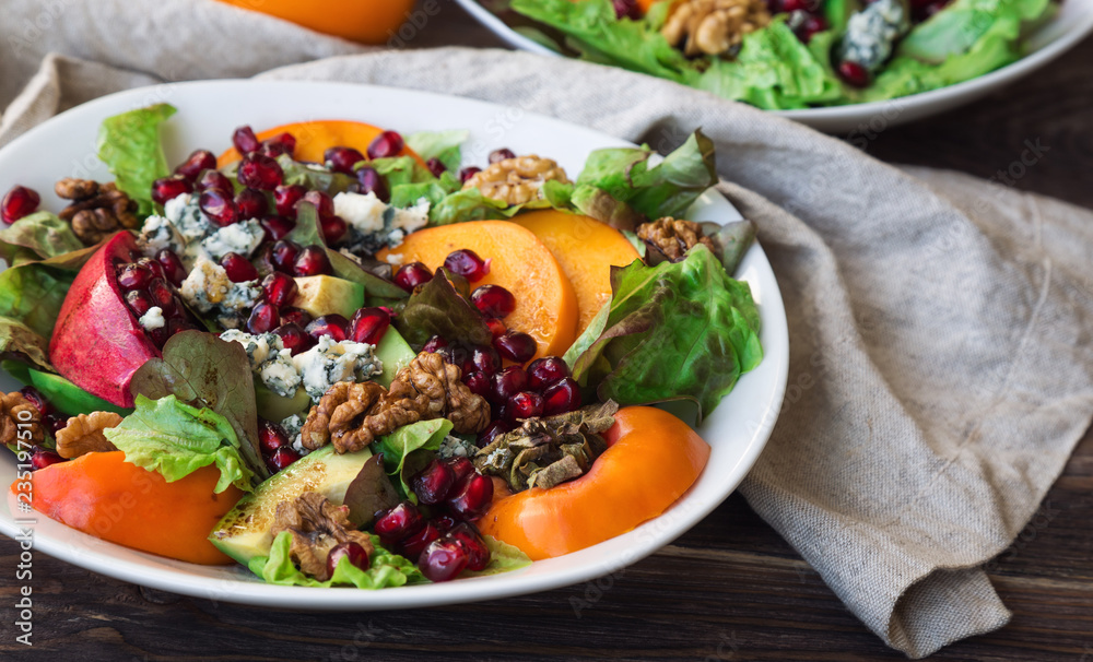 Wall mural autumn salad with persimmon, pomegranate, blue cheese and walnuts