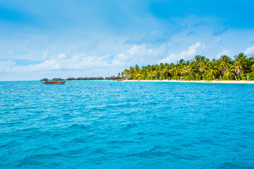 Beautiful sandy beach with sunbeds and umbrellas in Indian ocean, Maldives island