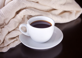 Cup of coffee and plaid on the wooden table