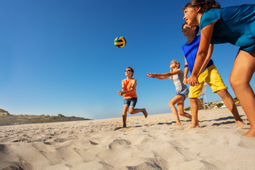 Children playing beach volleyball during vacation on the sea