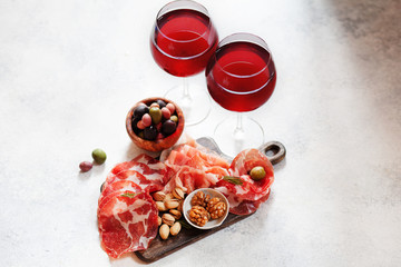 Meat plate, cold smoked pork, jamon, prosciutto, salami served with wine, nuts and olives