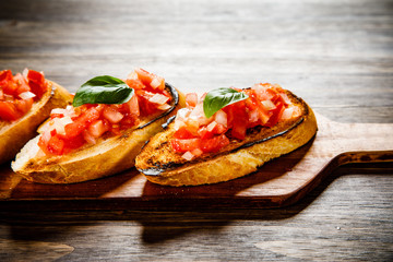 Bruschettas on cutting board on wooden background