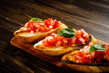 Bruschettas on cutting board on wooden background