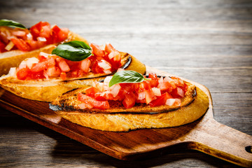 Bruschettas on cutting board on wooden background