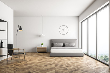 White bedroom with clock and armchair