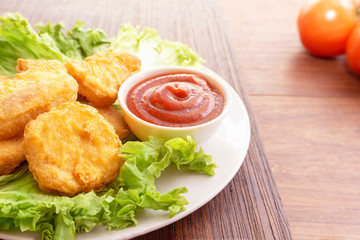 Chicken nuggets and sauce on a wooden background. Top view