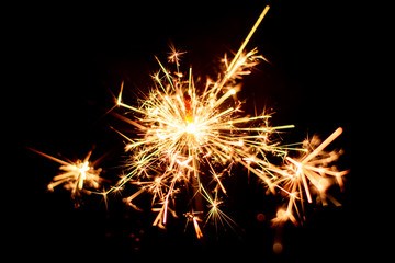 Christmas sparkler burning isolated on black background.
