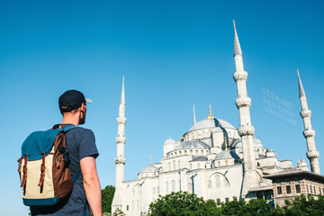 A tourist with a backpack admires the Blue Mosque in Istanbul in Turkey. Sightseeing.