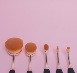 Set of oval brushes for makeup on pink background