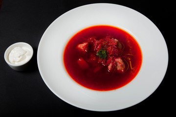 Borsch - a soup of beets in an earthenware bowl on a cipher, a stone or metal background, a traditional Ukrainian dish