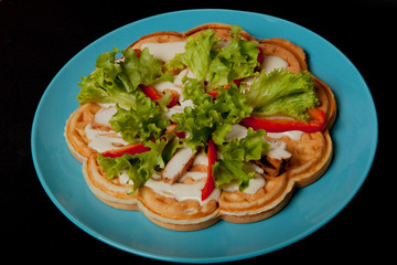 Homemade Belgian waffles with chicken fillet, for breakfast on a black background