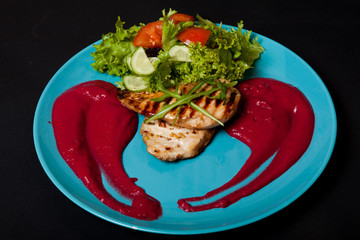 Chicken fillet cooked with mashed potatoes on a black background