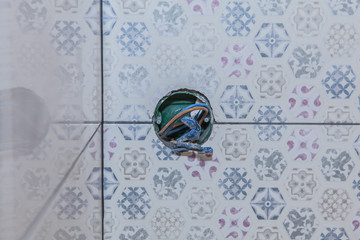 A place has been prepared for the installation of a wall outlet on a tile
