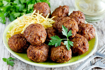 Turkish meatballs kuru kofte garnished with fried potato straws