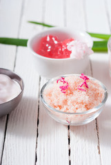 beauty and cosmetic creams with pink flowers on white wood