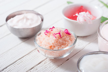 beauty and cosmetic creams with pink flowers on white wood