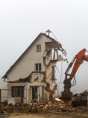 excavator demolishing  old residential building