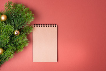 Background with decorated fir tree and blank notebook list in the middle. Top view with copy space. New year concept. Christmas concept. Winter concept.