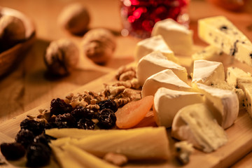 Some kinds of cheeses with nuts and apricots and raisins at the morning light
