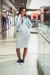 Young dark-skinned woman dressed in casual clothes in the mall