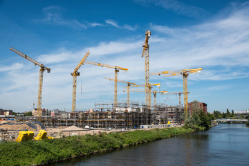 Many operating cranes at building site