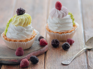 cakes with berries raspberries and blackberries. Posted on a wooden table