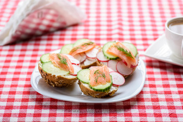 small sandwiches with salmon on vegetables