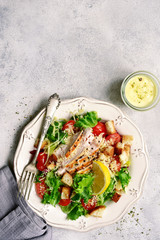 Caesar salad with grilled chicken, parmesan cheese, croutons and cherry tomatoes.Top view with copy space.