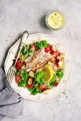 Caesar salad with grilled chicken, parmesan cheese, croutons and cherry tomatoes.Top view with copy space.