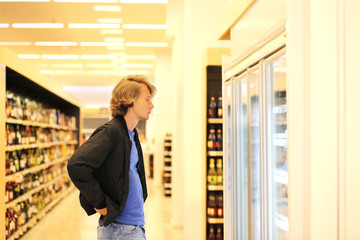 Fototapeta premium Man choosing frozen food from a supermarket freezer.