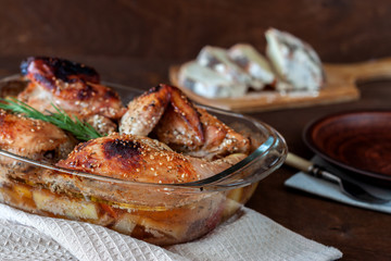 Baked turkey with potatoes in a glass dish on a wooden table. Thanksgiving Day