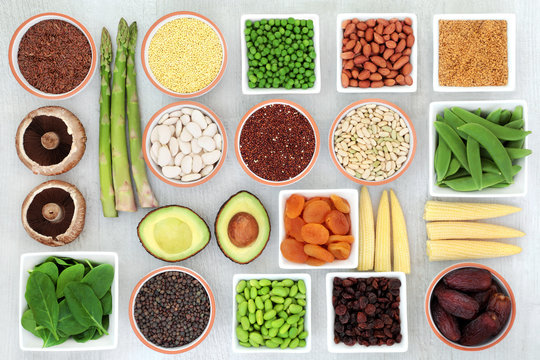 Protein plant health food selection for a healthy diet with grain, legumes, dried fruit, seeds, nuts and vegetables on rustic wood background. Foods high in fibre, antioxidants, vitamins and minerals.