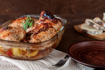 Baked turkey with potatoes in a glass dish on a wooden table. Thanksgiving Day