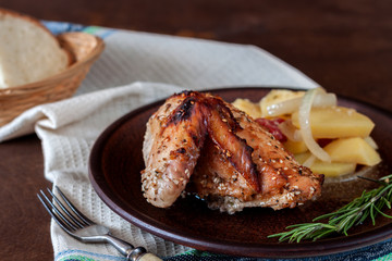Baked turkey with potatoes on a dish on a wooden table. Thanksgiving Day