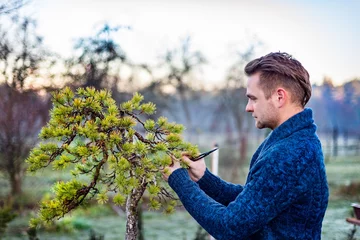 Papier peint photo Bonsaï Man pruning japanese bonsai tree  © Daniel Jędzura