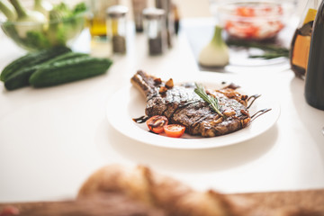 White kitchen table with delicious seasoned beef steak on plate