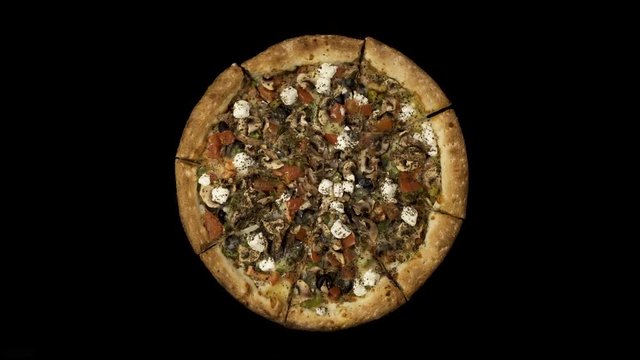 Rotating pizza with smoked sausage and olives on a black background. Top view center orientation