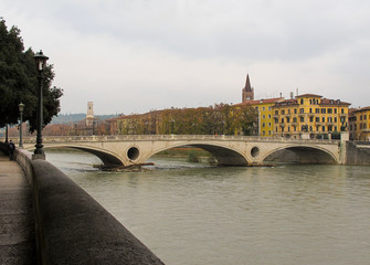 Obraz premium Old historical bridge Ponte della Vittoria across the Adige River in the center of Verona.