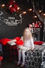 Lovely girl in purple dress in the background of Christmas decorations.