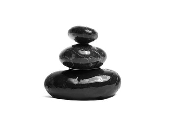 Stacked smooth black stones. Sea pebble. Balancing wet pebbles isolated on white background