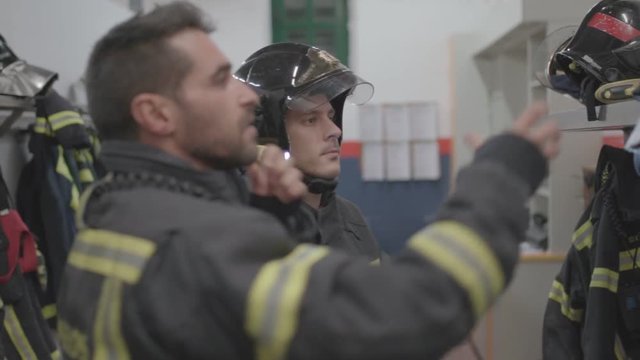 Two firefighters prepare for the uniform to work.