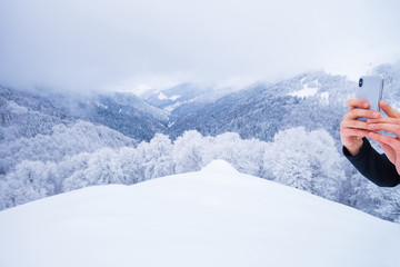 Using a white mobile phone to shoot a winter landscape panorama