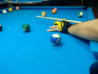 Playing billiard, A shot of a man playing billiard on a blue pool table