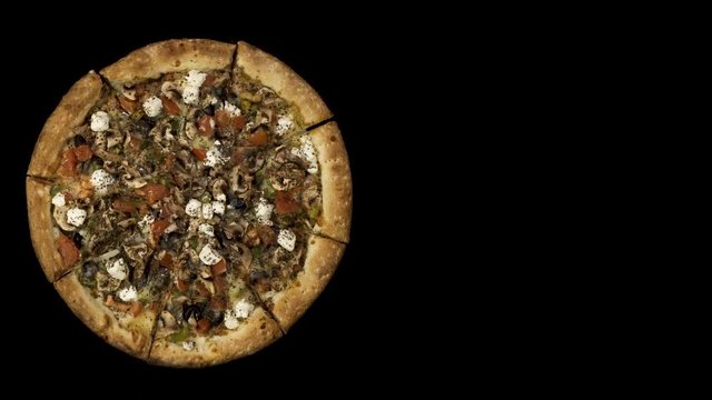 Rotating pizza with smoked sausage and olives on a black background. Top view center orientation
