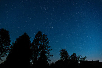 Fototapeta premium Starry sky with provincial village silhouette