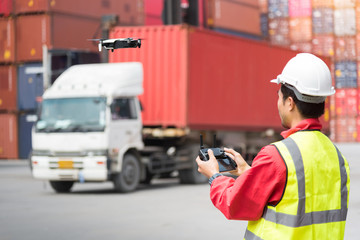 Foreman control drone to fly to survey the area worth in container yard