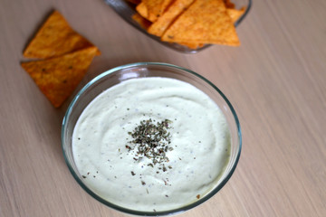 Bowl of broccoli, cheese and yoghurt dip and tortilla chips. Selective focus. 